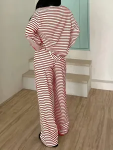 Back view of women's red and white striped long sleeve top and high waist pants lounge set.