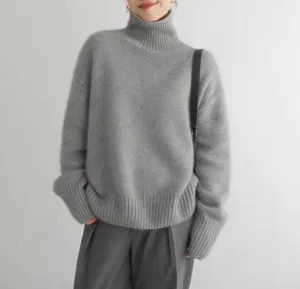 Détail d'un pull col roulé gris confortable, mettant en valeur sa maille douce.