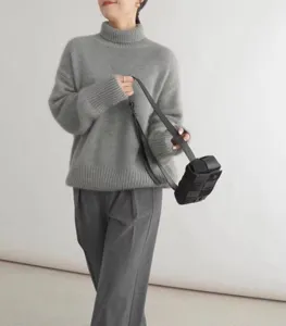 Vue détaillée du pull ample à col roulé gris pour femme, mode hivernale douillette.