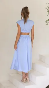 Back view detail shot of the light blue crop top and midi skirt set on minimalist white stairs.