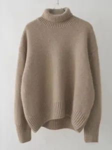 Gros plan du doux pull-over à col roulé camel montrant une texture confortable et côtes.