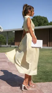 Yellow sleeveless cutout maxi dress, elegant outdoor detail shot showcasing trendy street style.
