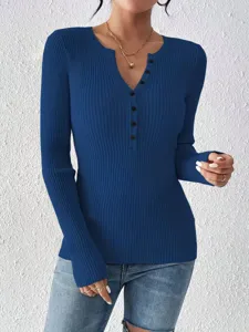 Detailopname van damestrui met lange mouwen, geribbelde breistof, V-hals en knoopsluiting detail.