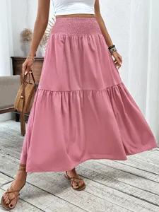 Solid pink tiered maxi skirt featuring high elastic waist, stylish long flowy design.
