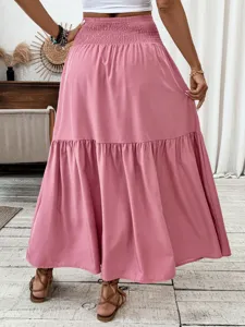 Detailed view of the solid pink tiered maxi skirt with a comfortable smocked high waist.