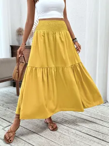 Detailed shot of yellow tiered maxi skirt with high elastic waist, casual resort style look.