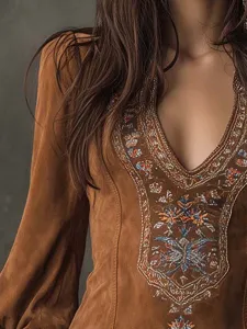 Vue rapprochée de la robe marron élégante à col en V avec des broderies détaillées.
