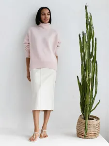 Gros plan detail de pull col roule rose femme decontracte coupe ample texture maille douce.