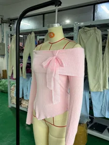 Vista dettagliata del top in maglia a costole rosa con spalle scoperte e fiocco.