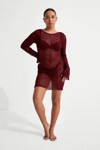 Close-up view of a chic sheer knit mini dress featuring long sleeves and stylish bodycon fit.
