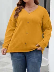 Close-up of mustard yellow V-neck knit sweater with vertical ribbing and front buttons.