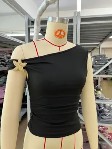Top corto nero asimmetrico e monospalla con elegante dettaglio di stella marina dorata.