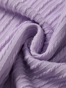 Close-up view of light purple cable knit sweater fabric showing soft texture and cozy detail.
