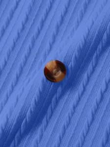 Close-up detail of blue vertical stripe knit fabric with tortoiseshell button texture.
