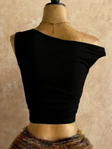 Vista dettagliata di un elegante top corto monospalla nero dalla vestibilità aderente.