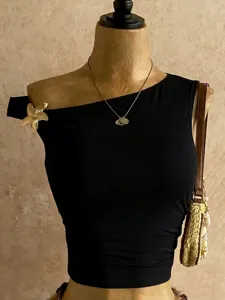 Vista di dettaglio di un elegante crop top nero asimmetrico monospalla da donna estivo.