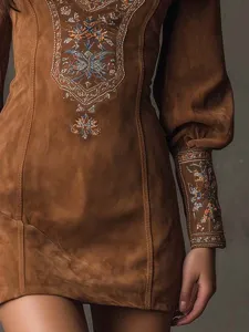 Vue détaillée de la robe courte en suédine marron avec broderies colorées raffinées.