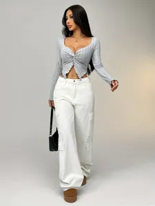 Detailaufnahme eines stilvollen grauen Twist-Front-Crop-Tops mit weißen Cargohosen.