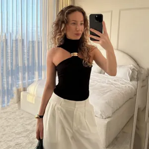 Women's black sleeveless halter top with stylish gold metal ring detail for summer wear.