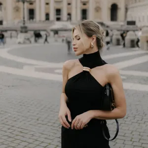 Close-up detail of a chic black halter neck top featuring a stylish metallic gold ring accent.