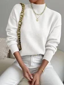 Primo piano del maglione bianco a collo alto, che mostra una morbida trama lavorata a maglia fine.