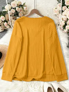 Detail view of the yellow ribbed knit sweater, showing soft texture and cozy long sleeves.