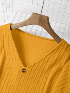 Yellow v-neck ribbed knit sweater detail shot, showing soft fabric and elegant texture.