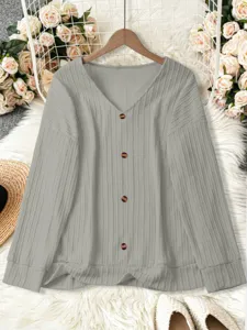 Detailed shot of casual solid color V-neck ribbed knit cardigan with button closure.