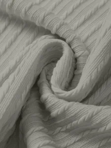 Detailed shot of white cable knit sweater fabric, soft texture, comfortable spring wear.