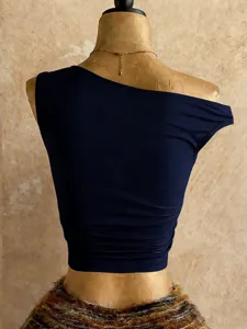 Vista dettagliata di un elegante crop top monospalla blu scuro per l'estate.