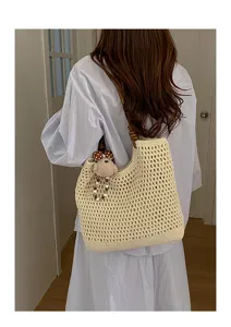 Dettaglio della borsa tote in maglia traforata crema con un simpatico orsetto