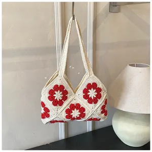 Handgefertigte Häkeltasche mit dekorativen roten Blumenmustern und Tragegriffen