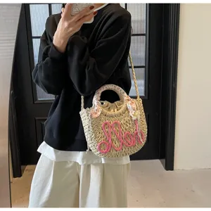 Summer woven straw bucket bag with pink Hello text and floral scarf handle detail