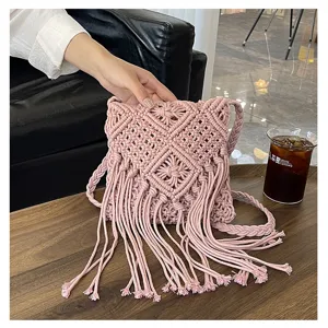 Detail view of a handmade pink macrame woven bag with long tassels for summer vacation