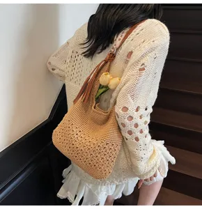 Bolso hobo de ganchillo hecho a mano con diseño floral calado y una borla marrón