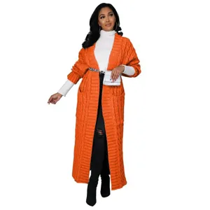 Detailweergave van het lange oranje kabelgebreide vest met handige zakken en gezellige stijl.