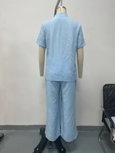 Dettaglio della vista posteriore del top a maniche corte azzurro e dei pantaloni lunghi.