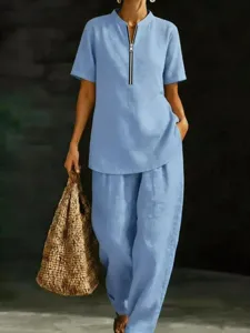 Set casual azzurro con top a maniche corte con zip e pantaloni lunghi comodi.