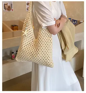 Detailed view of a stylish cream hand-woven hollow knit tote bag with starfish pendant