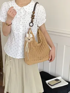 Korean style woven tote bag with wooden bead strap and teddy bear charm for beach travel.