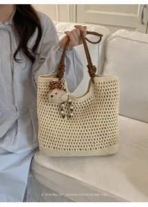 Vista dettagliata della borsa tote beige in maglia traforata con manici in pelle marrone
