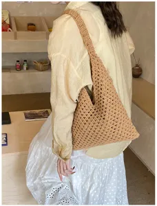 Detailed view of a handmade woven hollow-out tote bag in a warm tan summer style