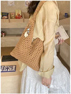 Detailed view of a hand-woven crochet beach tote bag with a decorative shell charm