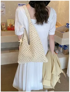 Detailed view of cream hand-woven crochet summer beach tote bag with a star charm accessory