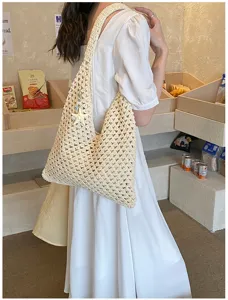 Handmade cream crochet summer tote bag with starfish charm accessory shown worn on shoulder