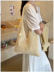 Detailed shot of a model carrying a handmade crochet summer beach bag with starfish charm