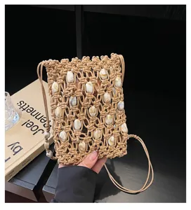 Close-up of handmade macrame woven phone bag featuring decorative beads and long shoulder strap