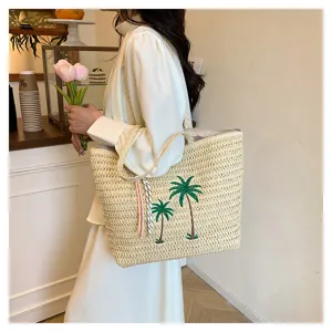 Woven straw tote bag featuring green coconut tree embroidery and colorful tassels