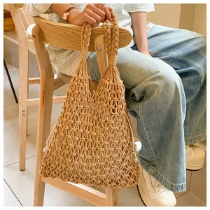 Detailed view of a handmade macramé woven tote bag with braided handles and drawstring.