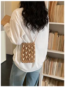 Back view of handmade bohemian woven crossbody phone bag with intricate shell bead details